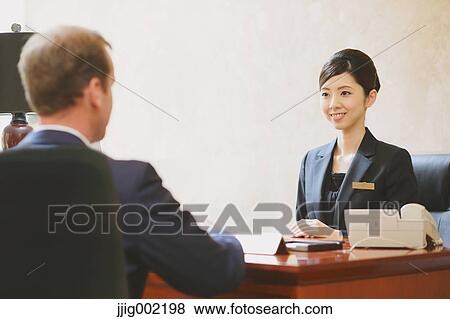 Japanese female hotel concierge dealing with a customer View Large Photo Image Stock Photo - Japanese female hotel concierge dealing with a customer. Fotosearch