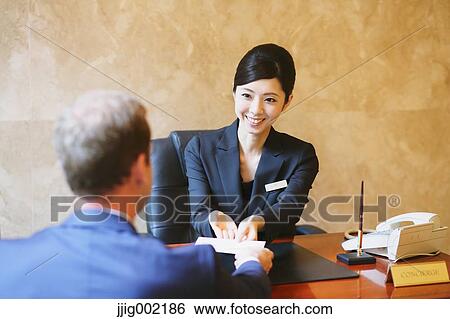 Japanese female hotel concierge dealing with a customer View Large Photo Image Stock Photograph - Japanese female hotel concierge dealing with a customer. Fotosearch