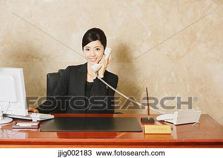 Stock Image - Japanese female hotel concierge. Fotosearch