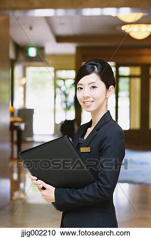 Stock Image - Japanese female hotel concierge. Fotosearch