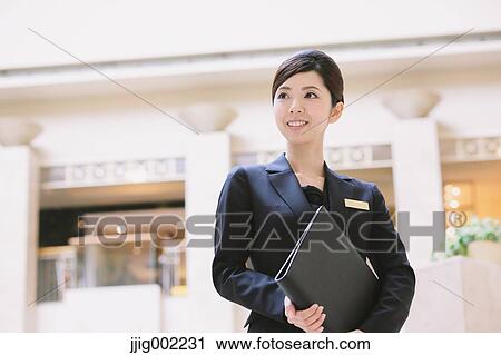 Stock Image - Japanese female hotel concierge. Fotosearch