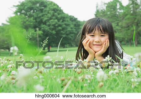 Japanese kid laying on grass in a park View Large Photo Image Picture - Japanese kid laying on grass in a park. Fotosearch