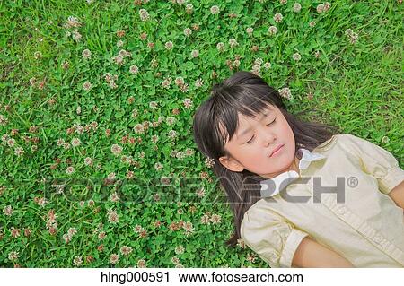 Japanese kid laying on grass in a park View Large Photo Image Stock Image - Japanese kid laying on grass in a park. Fotosearch