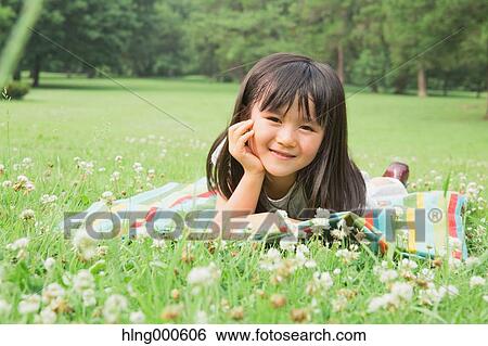 Japanese kid laying on grass in a park View Large Photo Image Stock Photograph - Japanese kid laying on grass in a park. Fotosearch