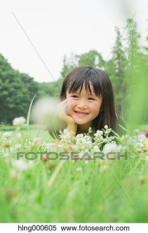 Japanese kid laying on grass in a park View Large Photo Image Stock Photography - Japanese kid laying on grass in a park. Fotosearch