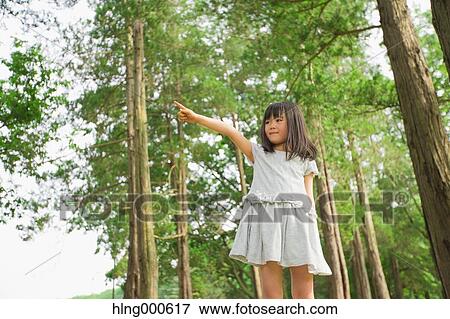 Japanese kid on tree trunk in a park View Large Photo Image Stock Photo - Japanese kid on tree trunk in a park. Fotosearch