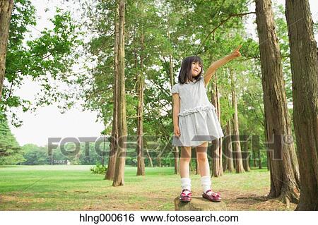 Japanese kid on tree trunk in a park View Large Photo Image Stock Photograph - Japanese kid on tree trunk in a park. Fotosearch