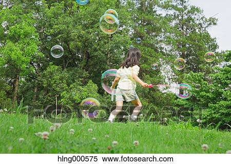 Japanese kid playing with soap bubbles in a park View Large Photo Image Stock Photography - Japanese kid playing with soap bubbles in a park. Fotosearch