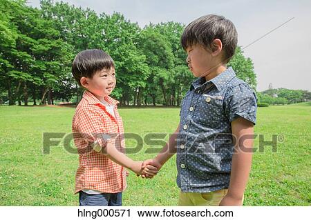 Japanese kid shaking hands in a park View Large Photo Image Stock Image - Japanese kid shaking hands in a park. Fotosearch