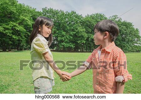 Japanese kid shaking hands in a park View Large Photo Image Stock Photo - Japanese kid shaking hands in a park. Fotosearch