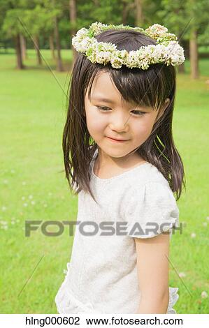 Stock Image - Japanese kid with flower tiara in a park. Fotosearch