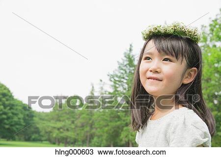 Stock Image - Japanese kid with flower tiara in a park. Fotosearch