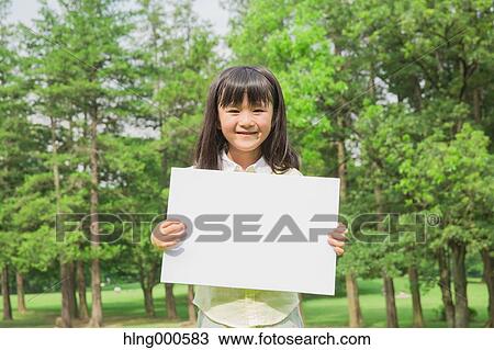 Stock Image - Japanese kid with whiteboard in a park. Fotosearch