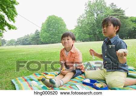 Stock Image - Japanese kids having picnic in a park. Fotosearch