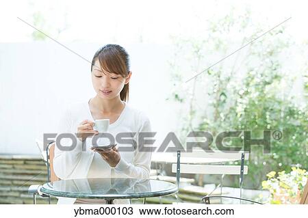 Attractive young girl having coffee outside View Large Photo Image Stock Image - Attractive young girl having coffee outside. Fotosearch