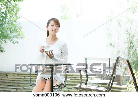 Stock Photograph - Attractive young girl having coffee outside. Fotosearch