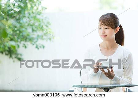 Attractive young girl having coffee outside View Large Photo Image Stock Photography - Attractive young girl having coffee outside. Fotosearch