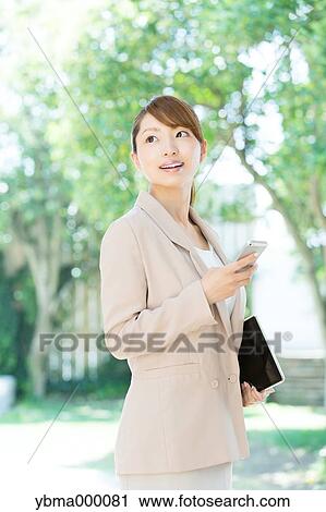 Stock Image - Attractive young girl with smartphone. Fotosearch