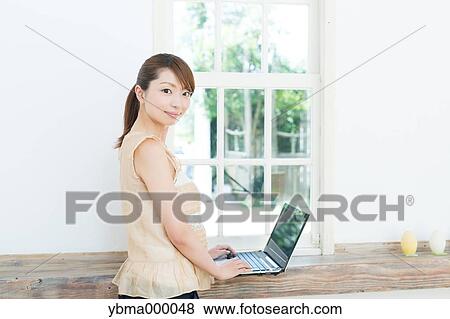 Attractive young girl working with laptop View Large Photo Image Stock Photo - Attractive young girl working with laptop. Fotosearch
