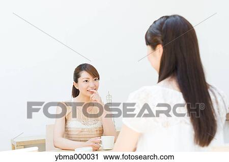 Attractive young girls chatting over a cup of coffee View Large Photo Image Stock Image - Attractive young girls chatting over a cup of coffee. Fotosearch