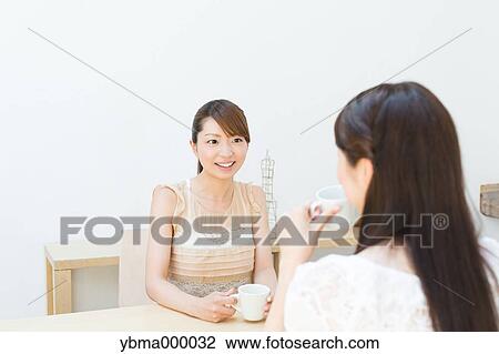 Attractive young girls chatting over a cup of coffee View Large Photo Image Stock Image - Attractive young girls chatting over a cup of coffee. Fotosearch