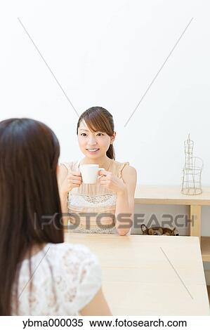 Attractive young girls chatting over a cup of coffee View Large Photo Image Stock Photography - Attractive young girls chatting over a cup of coffee. Fotosearch