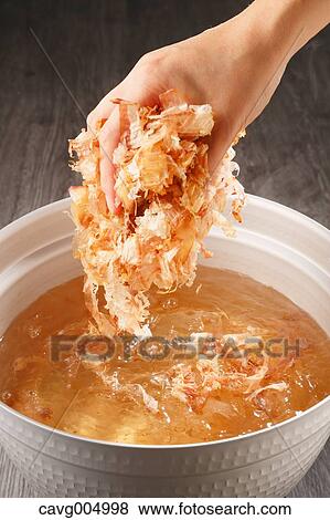 Stock Photo - Young Japanese girl adding Katsuobushi to soup. Fotosearch