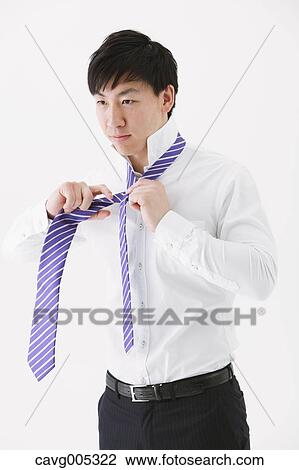 Businessman tying a necktie View Large Photo Image Stock Image - Businessman tying a necktie. Fotosearch