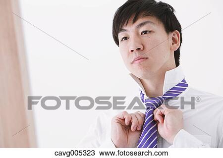 Businessman tying a necktie View Large Photo Image Stock Image - Businessman tying a necktie. Fotosearch
