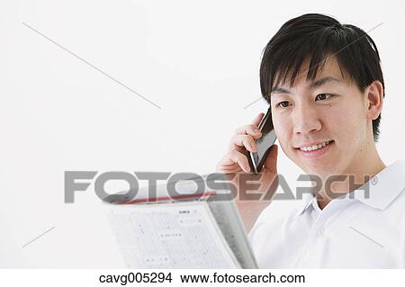 Picture - Businessman with newspaper and phone. Fotosearch