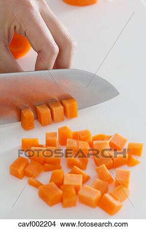 Close up of woman's hands slicing carrots with a kitchen knife View Large Photo Image Picture - Close up of woman's hands slicing carrots with a kitchen knife. Fotosearch