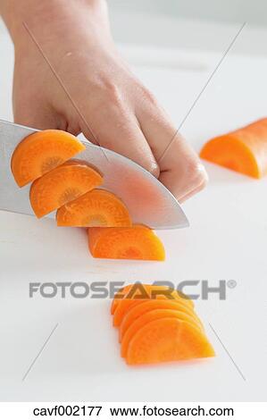 Close up of woman's hands slicing carrots with a kitchen knife View Large Photo Image Stock Photo - Close up of woman's hands slicing carrots with a kitchen knife. Fotosearch