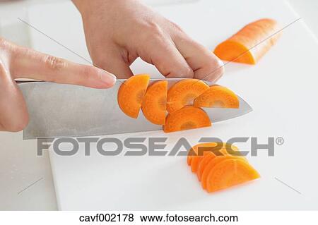 Close up of woman's hands slicing carrots with a kitchen knife View Large Photo Image Stock Photo - Close up of woman's hands slicing carrots with a kitchen knife. Fotosearch