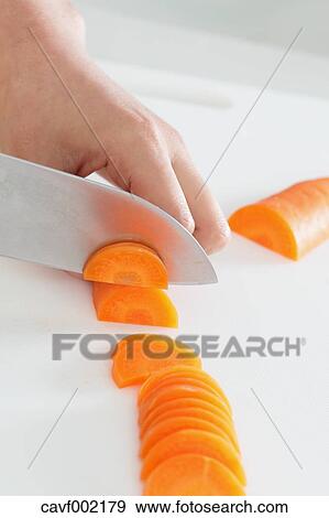 Close up of woman's hands slicing carrots with a kitchen knife View Large Photo Image Stock Photo - Close up of woman's hands slicing carrots with a kitchen knife. Fotosearch