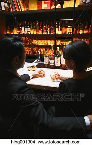 Couple drinking in a fashionable bar View Large Photo Image Picture - Couple drinking in a fashionable bar. Fotosearch