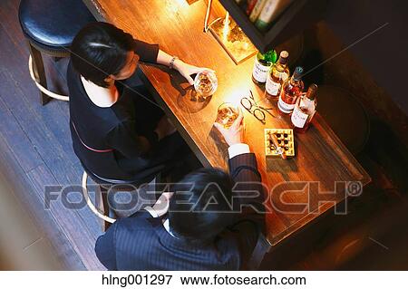 Couple drinking in a fashionable bar View Large Photo Image Stock Photo - Couple drinking in a fashionable bar. Fotosearch