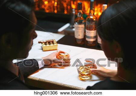 Couple drinking in a fashionable bar View Large Photo Image Stock Photograph - Couple drinking in a fashionable bar. Fotosearch