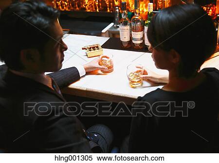Couple drinking in a fashionable bar View Large Photo Image Stock Photography - Couple drinking in a fashionable bar. Fotosearch