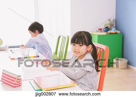 Elementary age brother and sister doing homework at their desk View Large Photo Image Stock Photo - Elementary age brother and sister doing homework at their desk. Fotosearch