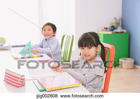 Elementary age brother and sister doing homework at their desk View Large Photo Image Stock Photo - Elementary age brother and sister doing homework at their desk. Fotosearch