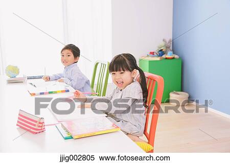 Elementary age brother and sister doing homework at their desk View Large Photo Image Stock Photography - Elementary age brother and sister doing homework at their desk. Fotosearch