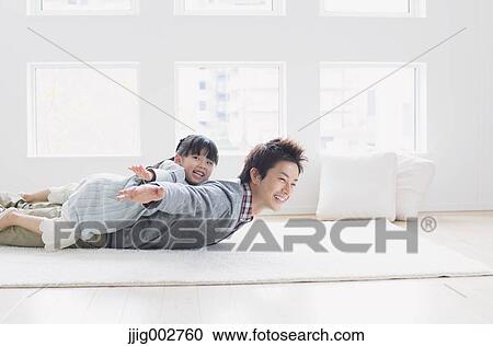 Elementary age girl laying on his fathers back and smiling View Large Photo Image Stock Image - Elementary age girl laying on his fathers back and smiling. Fotosearch