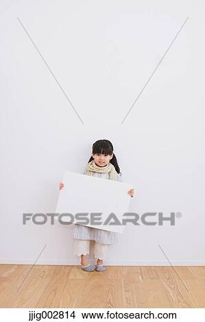 Elementary age girl leaning against a white wall with whiteboard View Large Photo Image Picture - Elementary age girl leaning against a white wall with whiteboard. Fotosearch