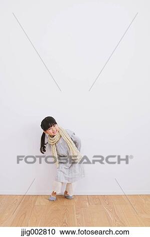 Elementary age girl leaning against a white wall and smiling at camera View Large Photo Image Stock Image - Elementary age girl leaning against a white wall and smiling at camera. Fotosearch