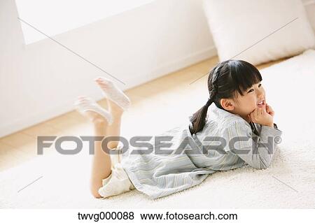 Elementary age girl lying on the floor View Large Photo Image Stock Photo - Elementary age girl lying on the floor. Fotosearch