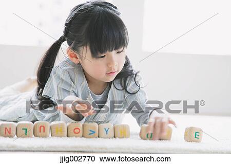 Elementary age girl playing with wooden alphabet cubes on the floor View Large Photo Image Stock Image - Elementary age girl playing with wooden alphabet cubes on the floor. Fotosearch