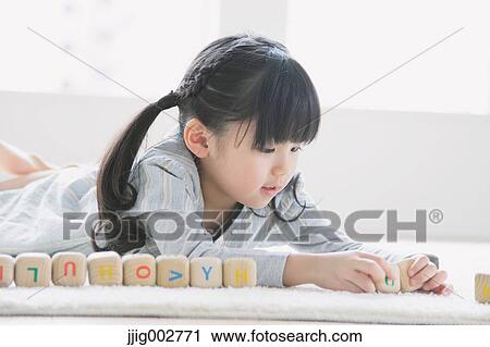 Elementary age girl playing with wooden alphabet cubes on the floor View Large Photo Image Stock Image - Elementary age girl playing with wooden alphabet cubes on the floor. Fotosearch