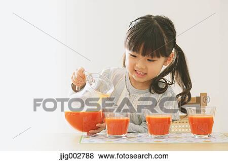 Elementary age girl pouring tomato juice into glasses View Large Photo Image Stock Photo - Elementary age girl pouring tomato juice into glasses. Fotosearch