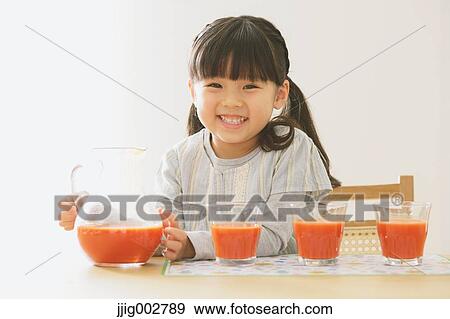 Elementary age girl pouring tomato juice into glasses View Large Photo Image Stock Photo - Elementary age girl pouring tomato juice into glasses. Fotosearch