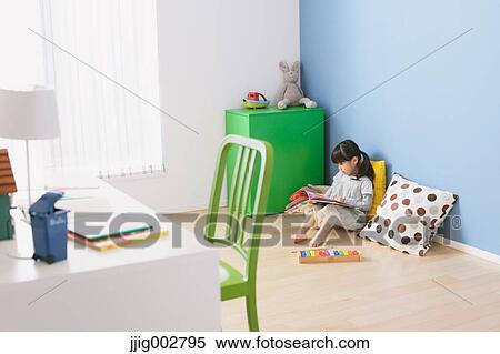 Elementary age girl reading an illustrated book on the floor of the kids room View Large Photo Image Stock Photography - Elementary age girl reading an illustrated book on the floor of the kids room. Fotosearch